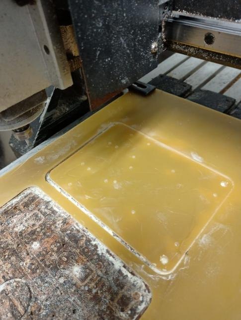 Another view of the base plate on the CNC router bed after machining